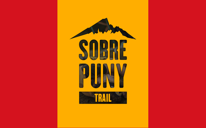 Logo de la sobrepunyt, imatge amb fons groc i el nom de la sobrepuny en negre, amb un logotip d'una muntanya a sobre.