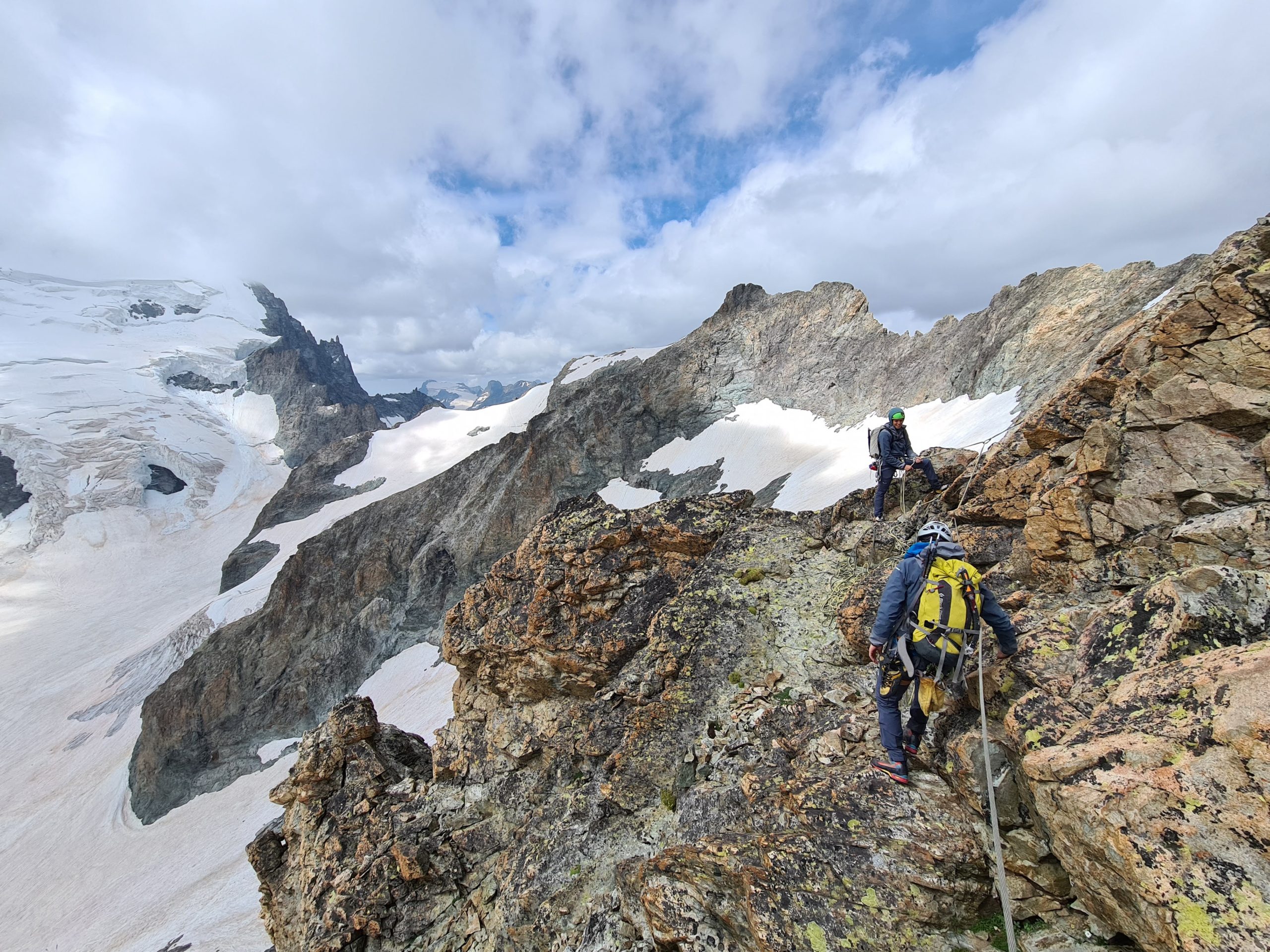dos esportistes fent alpinisme per una muntanya rocosa